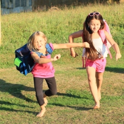 junge Schülerinnen mit Schultaschen