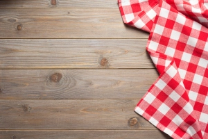 Tischdecke auf einen Holztisch legen