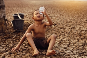 Ungerechte Verteilung des Wassers: Kind in Wüste auf der Suche nach Wasser